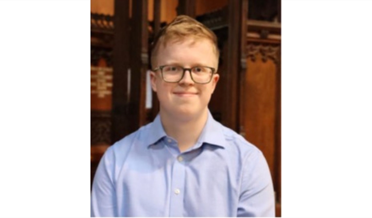 A photo of James Watson sat in front of an organ