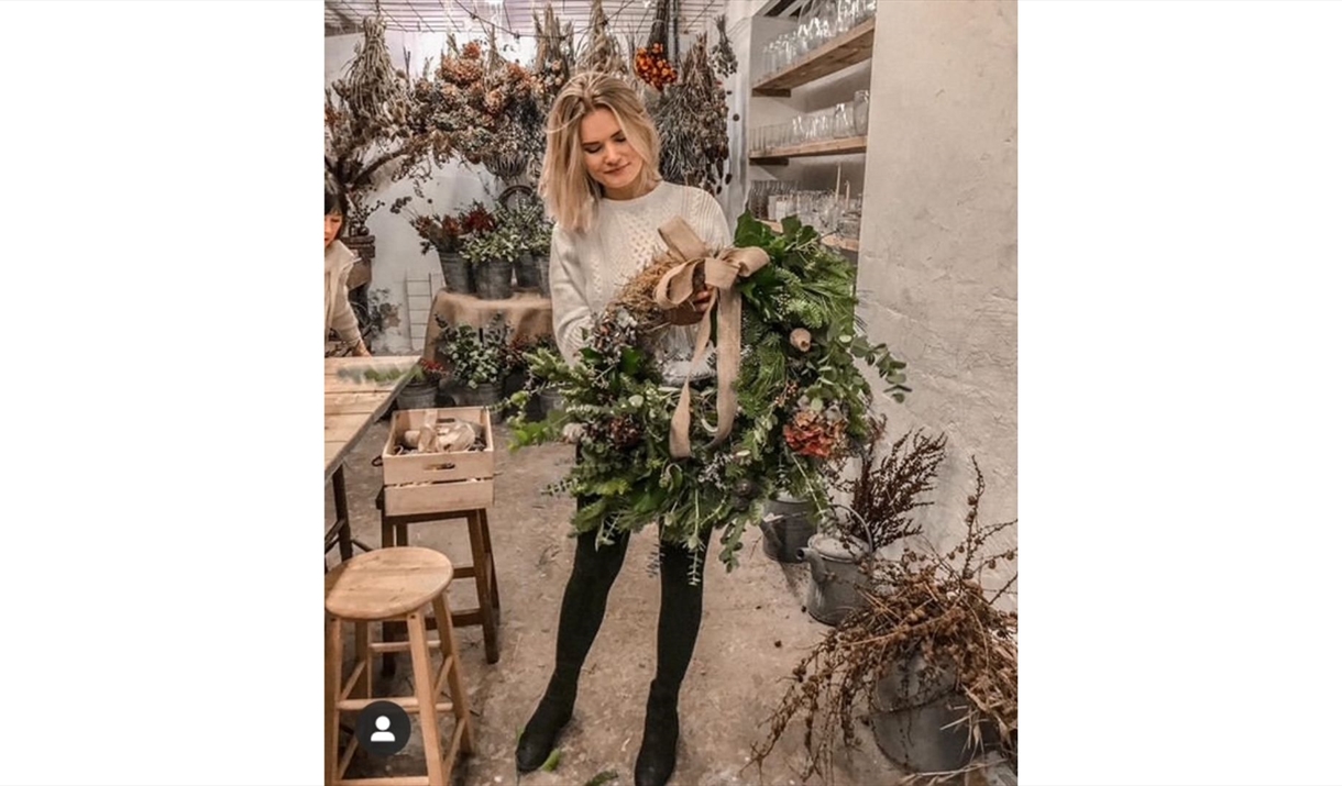 A girl holding a Christmas wreath