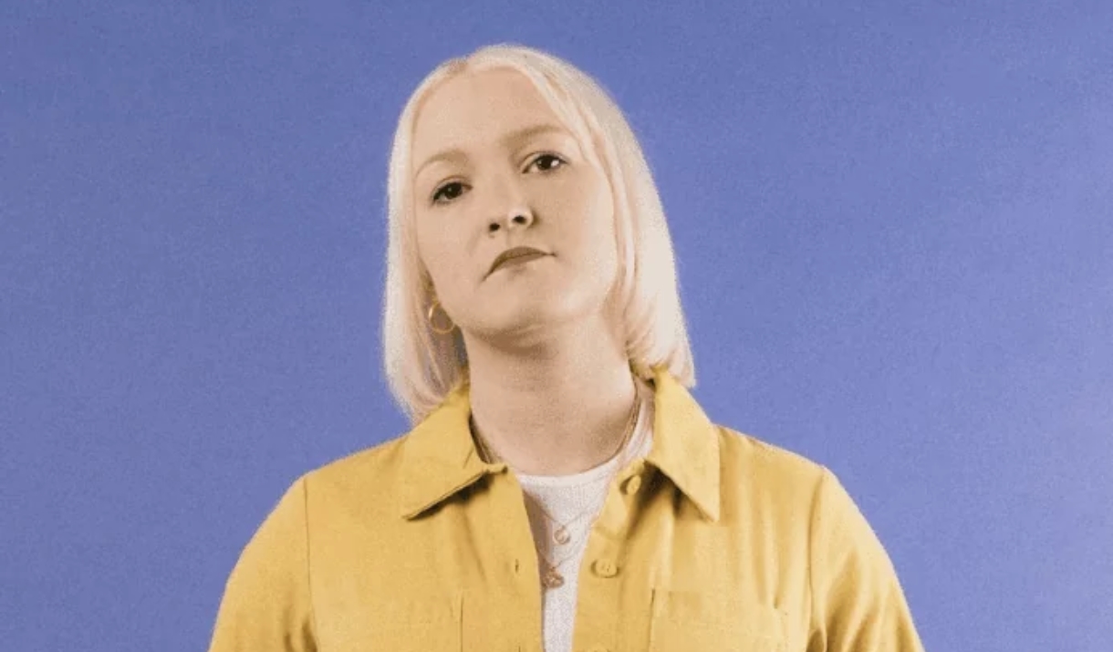 person wearing a yellow outfit in front of a purple background