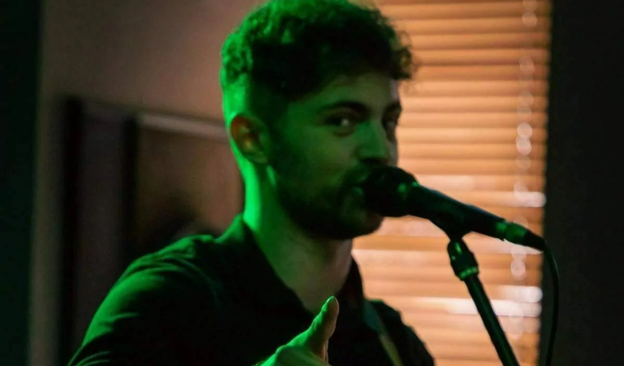 Person playing guitar and looking in the camera