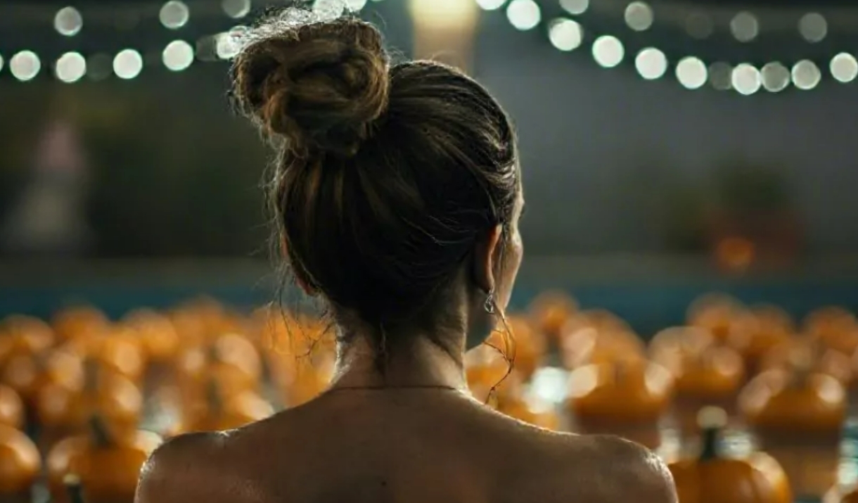 women looking over a pumpkin patch at night