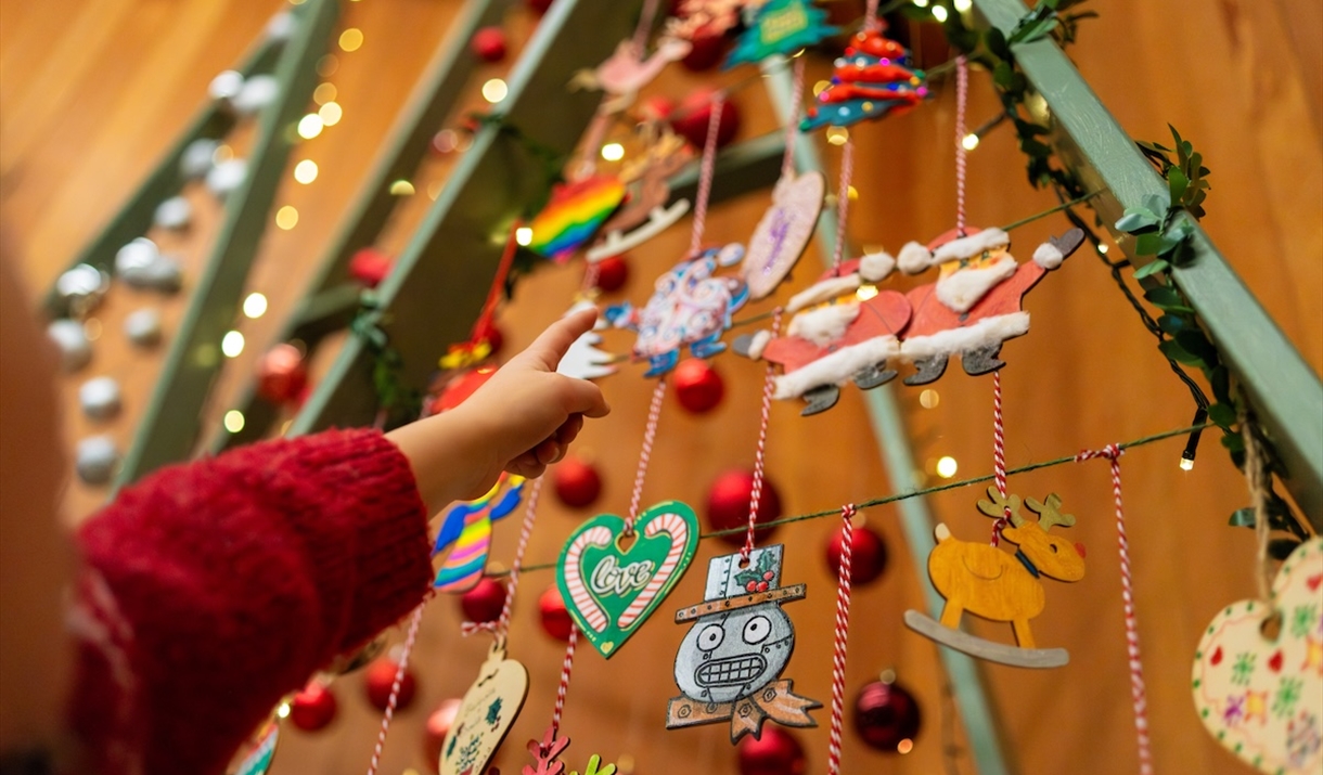 A child pointing at some Christmas decorations