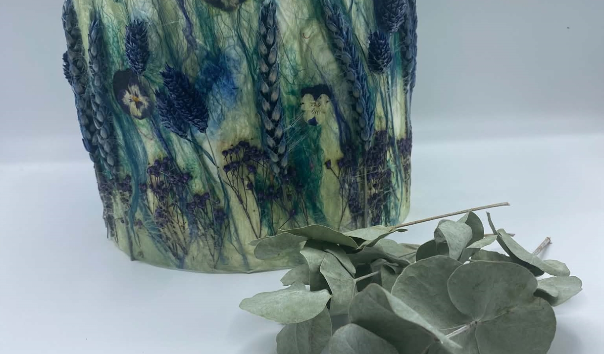 A green and blue floral print lampshade featuring intricate leaf designs, showcasing a vibrant and nature-inspired pattern.