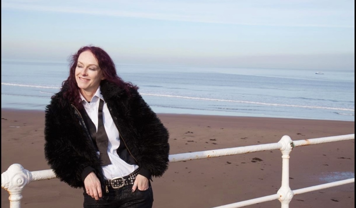 person posing by the sea