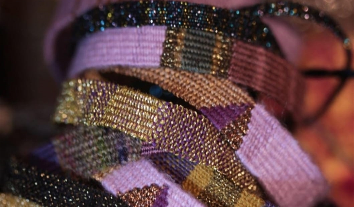 A stack of four colorful bracelets arranged together, showcasing a variety of vibrant hues and designs.