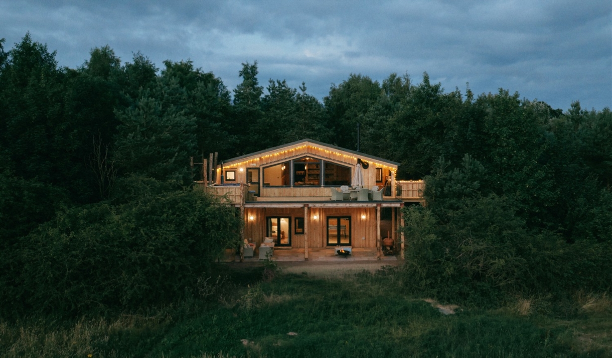 Exterior of Luna Treehouse at Into the Woods at nighttime near Little Salkeld, Cumbria