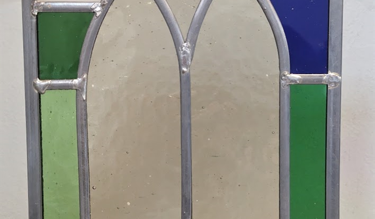 a person holding up a stained glass window