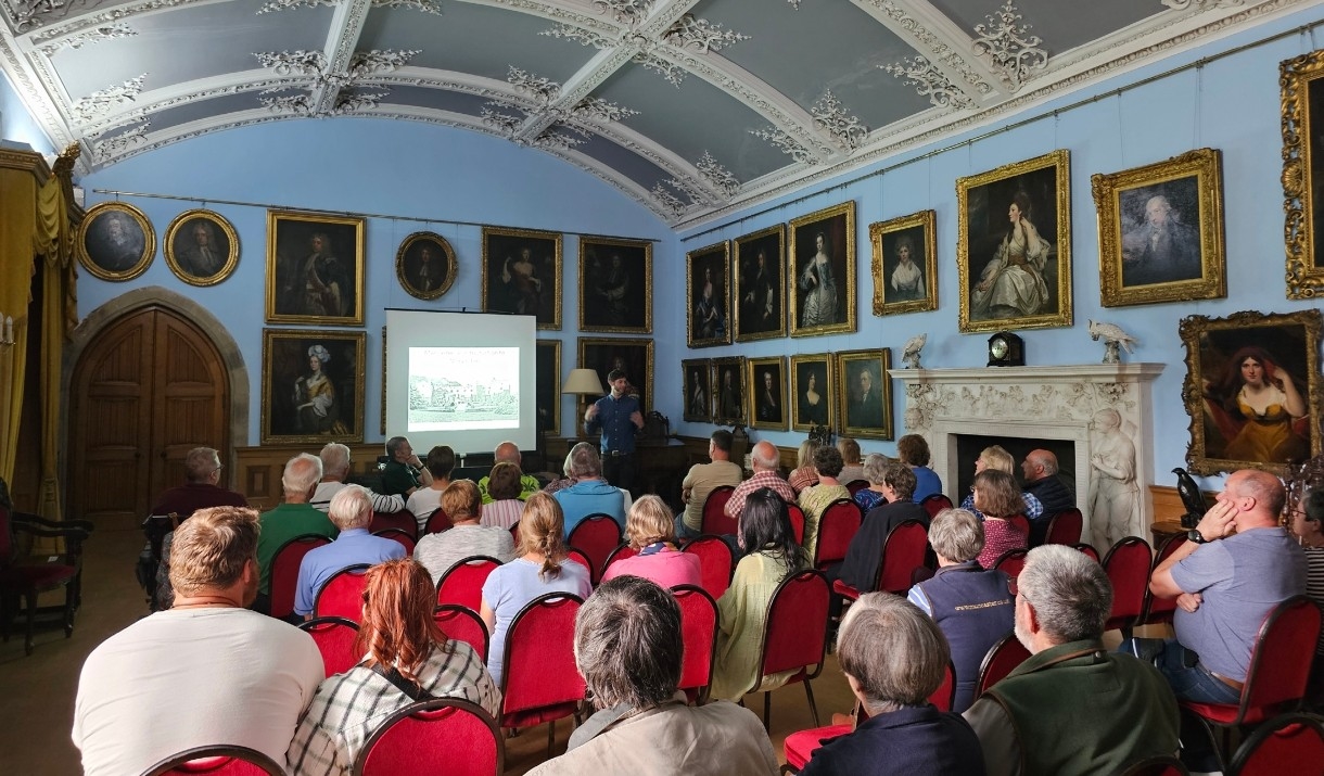 Audience listening to a talk in the Drawing Room of Muncaster Castle