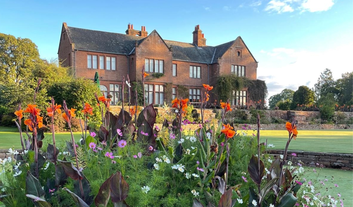 Sanstone manor house Nunwick Hall in the background with beautifully landscaped flowering gardens in the foreground