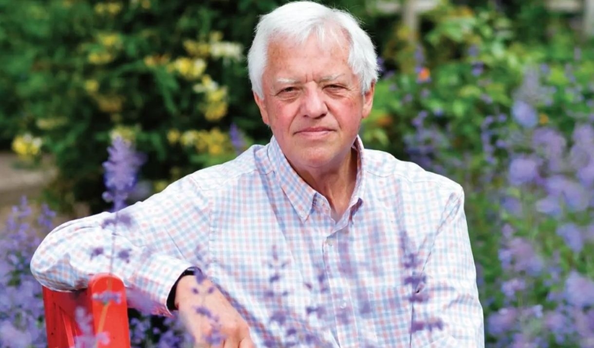 Peter Hughes surrounded by flowers.