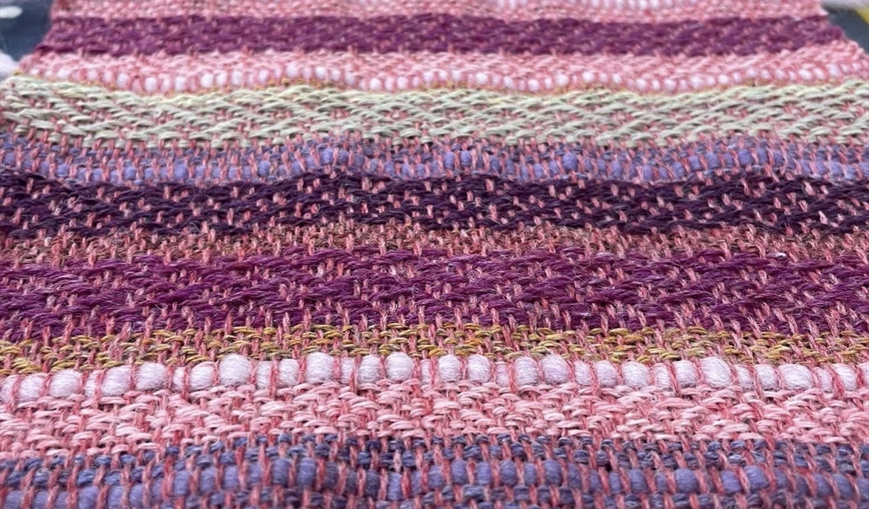 Close-up of a vibrant striped scarf featuring various colors and patterns, showcasing its texture and design.