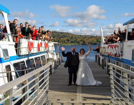 Bridal Couple and Wedding Guests on a Jetty and Windermere Lake Cruises Vessels in the Lake District, Cumbria