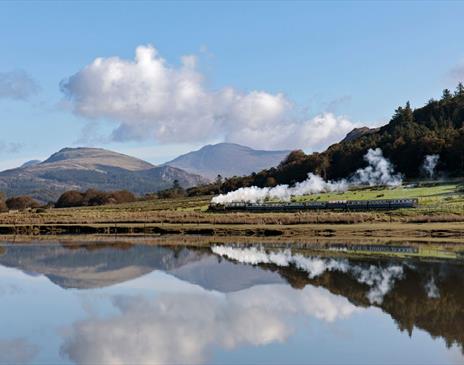 Ravenglass and Eskdale Railway Train with a scenic mountain backdrop and lake reflection © Mark Fielding