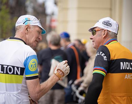 Two cyclists chatting to each other both wearing vintage cycling attire