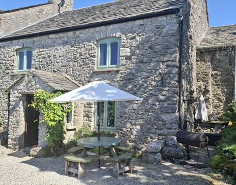 Exterior and outdoor seating at The Old Farmhouse at Brackenthwaite Farm near Arnside
