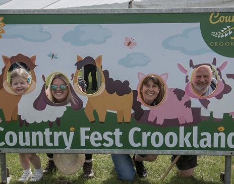 Visitors pose at a photo board at Country Fest in Crooklands, Cumbria