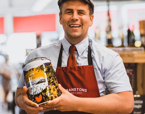 Employee with local beer at Cranstons Cumbrian Food Hall in Penrith, Cumbria