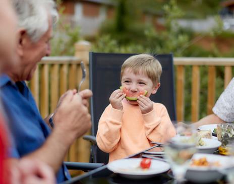 Family Enjoying a Meal at a Gatebeck Holiday Park Holiday Home in Gatebeck, Cumbria