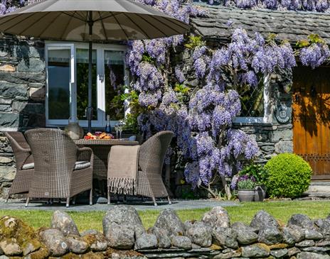 Exterior of Stone Cottage in Patterdale, Lake District with Wisteria and outdoor patio seating