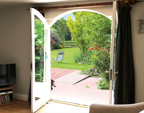 Double doors leading to the garden and outdoor seating at The Cottage at Linden Farm House in Langwathby, Cumbria