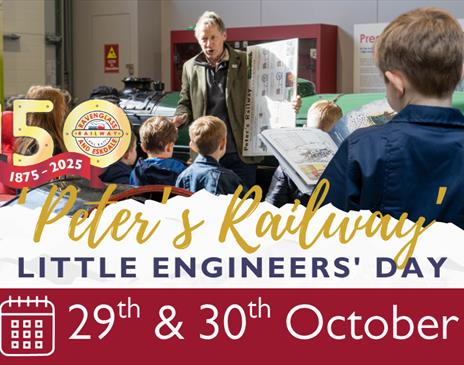 Photo of a man in front of a train presenting to children with notebooks