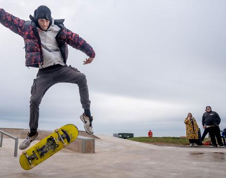 Visitor doing skateboard tricks at Maryport Skate Park in Maryport, Cumbria