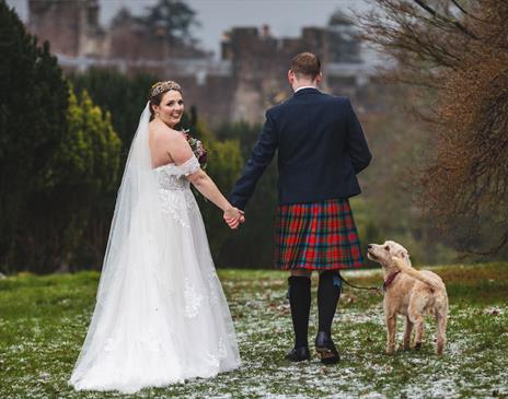 Bride and Groom Posing with Scenery at Muncaster Castle in Ravenglass, Lake District