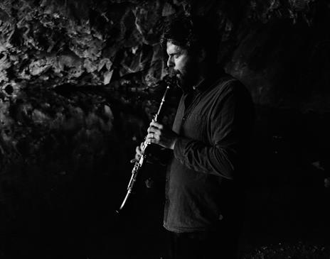 A person playing a clarinet in a cave