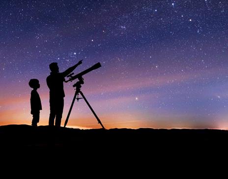 Silhouette of a Family Stargazing with a Telescope