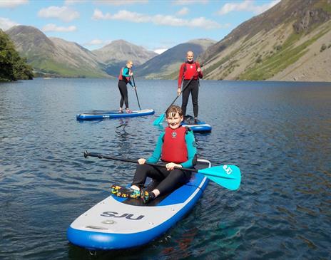 Visitors Paddleboarding in the Lake District with Path to Adventure