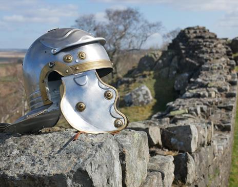 A Roman-style helmet resting on a Hadrian's wall