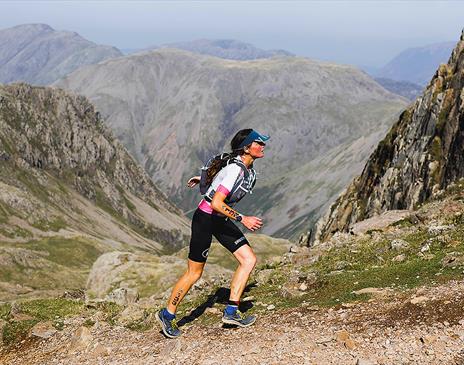 Female fell runner running up a mountain in the lake district Cumbria