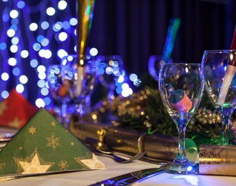 Picture of a Christmas party dinning table with crackers and fairy lights