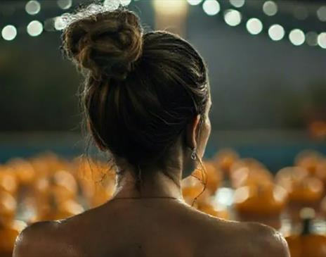 women looking over a pumpkin patch at night