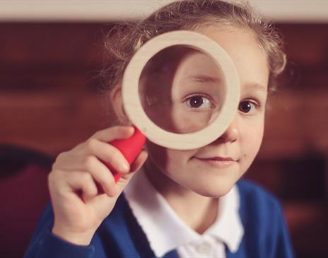 Child with a Magnifying Glass, Advert for The Wild Escape at Quaker Tapestry Museum in Kendal, Cumbria