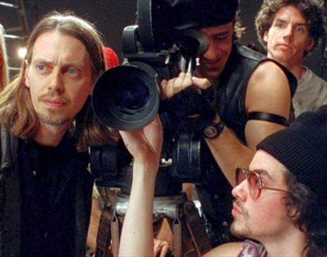 Still from the film "Living in Oblivion". showing the actors huddled around a camera.
