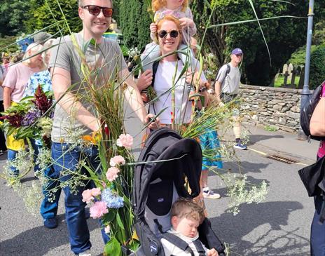 A family participating in a Procession through Grasmere
