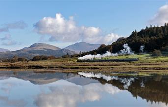 Ravenglass and Eskdale Railway Train with a scenic mountain backdrop and lake reflection © Mark Fielding