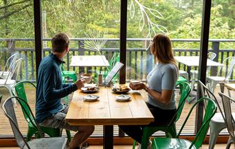 Couple enjoying lunch at at Cafe Ambio in Whinlatter Forest in the Lake District, Cumbria