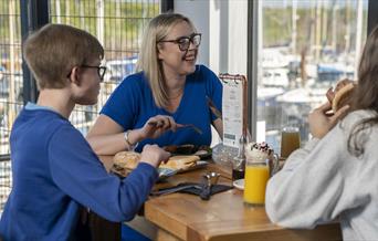 Family having food & drink at Marina View Cafe in Maryport, Cumbria