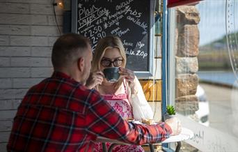 Visitors having coffee at The Wharf Ice Cream and Coffee House in Maryport, Cumbria