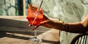 Visitor holding an Aperol Spritz at BAHA in Bowness-on-Windermere, Lake District