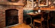 Dining room seating and real log burner at The Ambleside Inn in Ambleside, Lake District