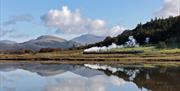 Ravenglass and Eskdale Railway Train with a scenic mountain backdrop and lake reflection © Mark Fielding
