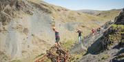 Climbers Crossing the Infinity Bridge at Via Ferrata Xtreme at Honister Slate Mine in Borrowdale, Lake District