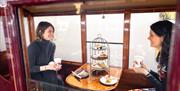 Visitors aboard a Ravenglass and Eskdale Railway train having cream tea © Ben Barden Photography