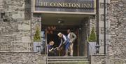 Guests with dog at the entrance to The Coniston Inn, Coniston, Lake District