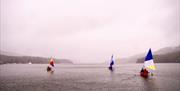 Three sailng canoes in the mist