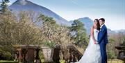 Happy Couple Posing for Wedding Photos with Mountain Backdrop at Armathwaite Hall Hotel and Spa in Bassenthwaite, Lake District