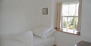 Single bedroom with window overlooking open area at the back and traditional dressing table in No. 3 Main Street Cottage in Elterwater, Lake District